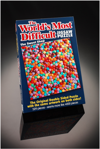A picture of a jigsaw puzzle titled "The world's most difficult" and showing a field of small round candies. It boasts the same artwork on both sides.